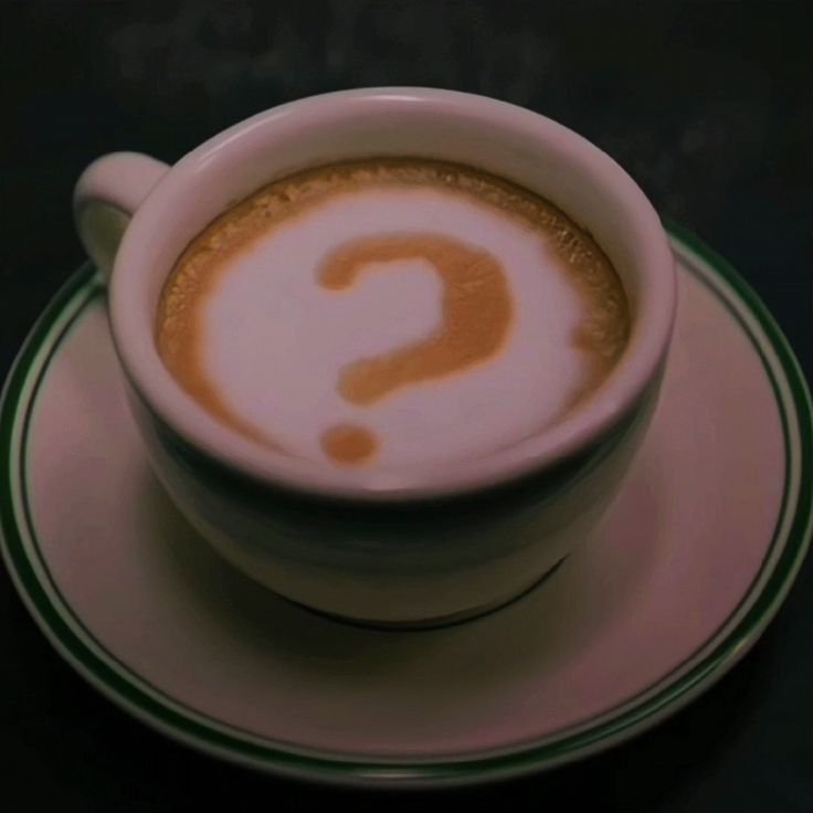 a cup of coffee with a question mark painted on it