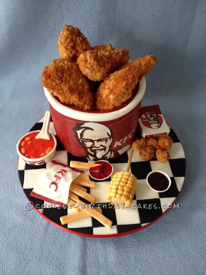 fried chicken in a bucket with fries and ketchup on a checkered plate