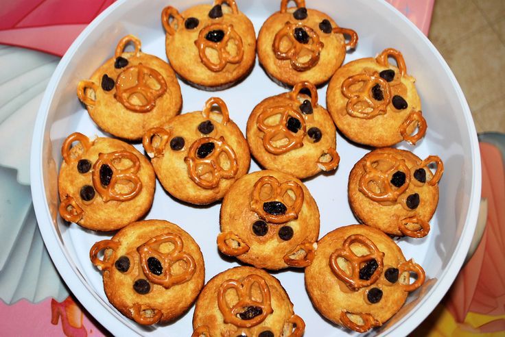 a white plate topped with cookies shaped like teddy bears and pretzel heads on top of each other