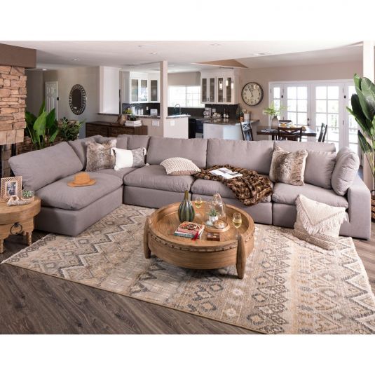 a living room filled with furniture and a large rug on top of a wooden floor