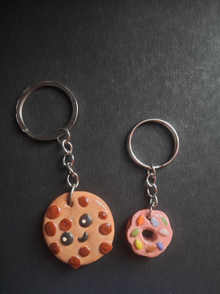 two key chains with doughnuts and sprinkles on them sitting next to each other