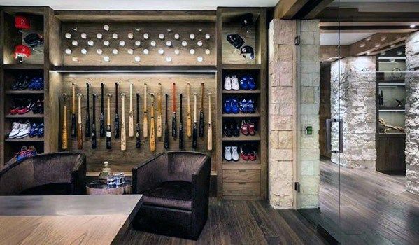 the inside of a baseball dugout with many bats and equipment on display in it