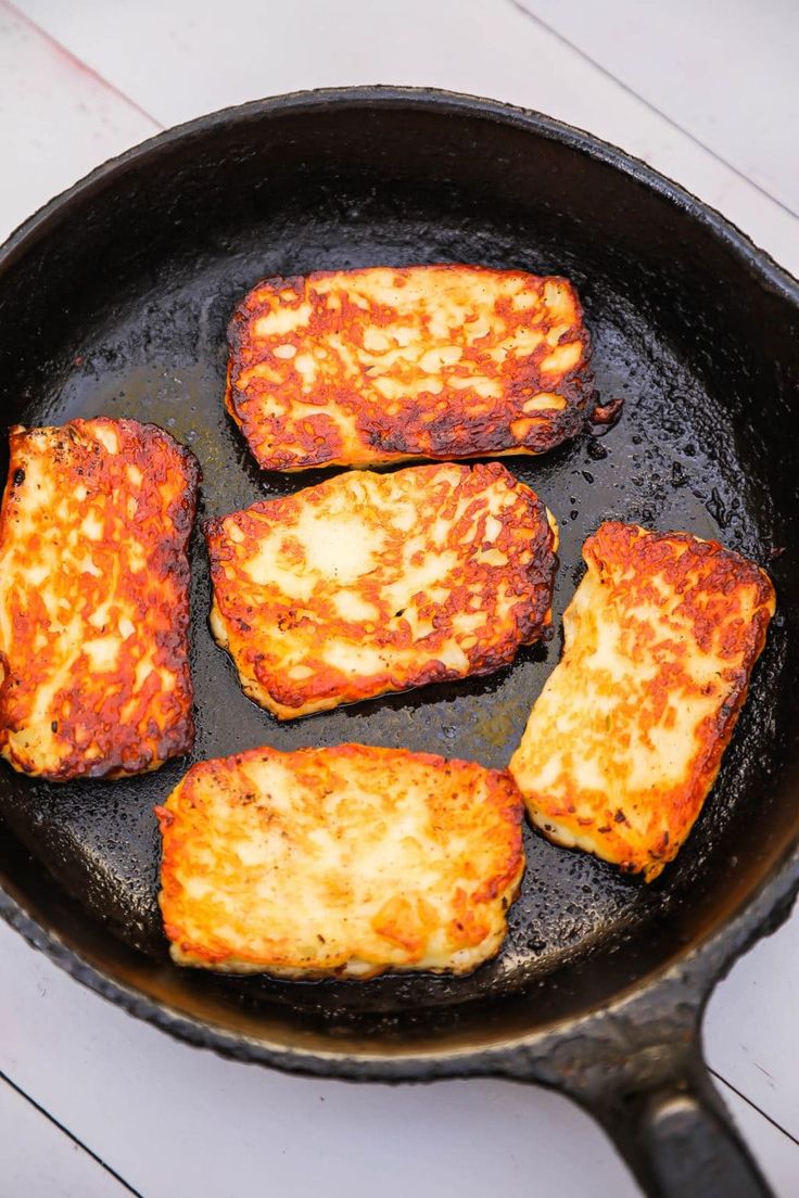 four pieces of food cooking in a frying pan