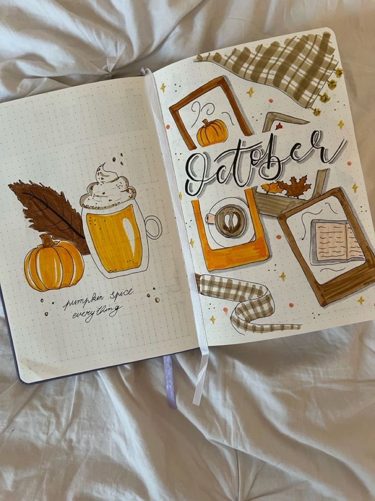 an open notebook with the words october written on it and two pumpkins in front