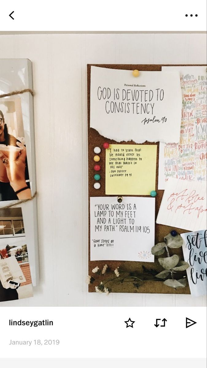 a bulletin board with pictures and notes attached to it, hanging on a white wall