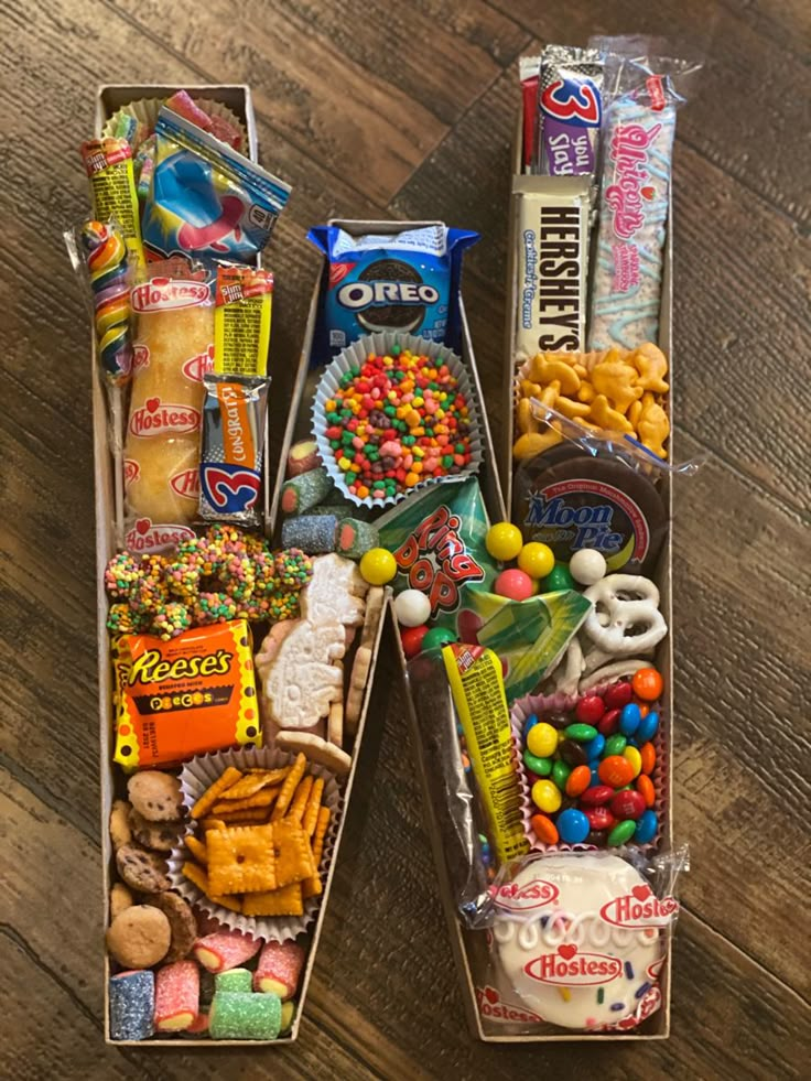 two boxes filled with candy and candies on top of a wooden table