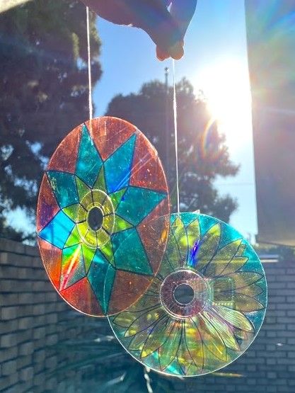 the sun shines brightly behind two colorful wind catchers