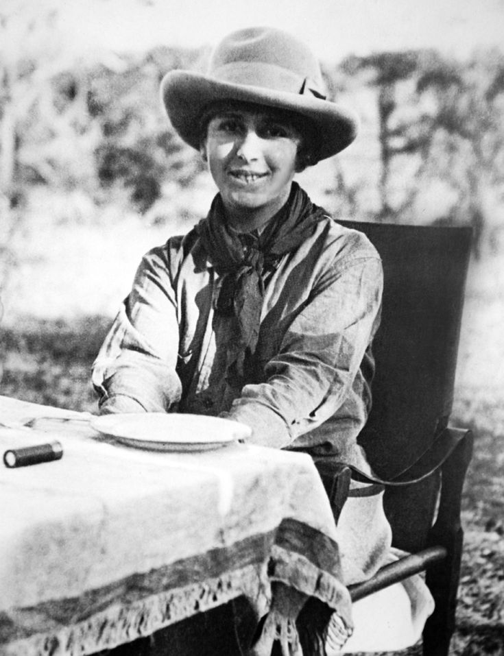 a man sitting at a table wearing a cowboy hat