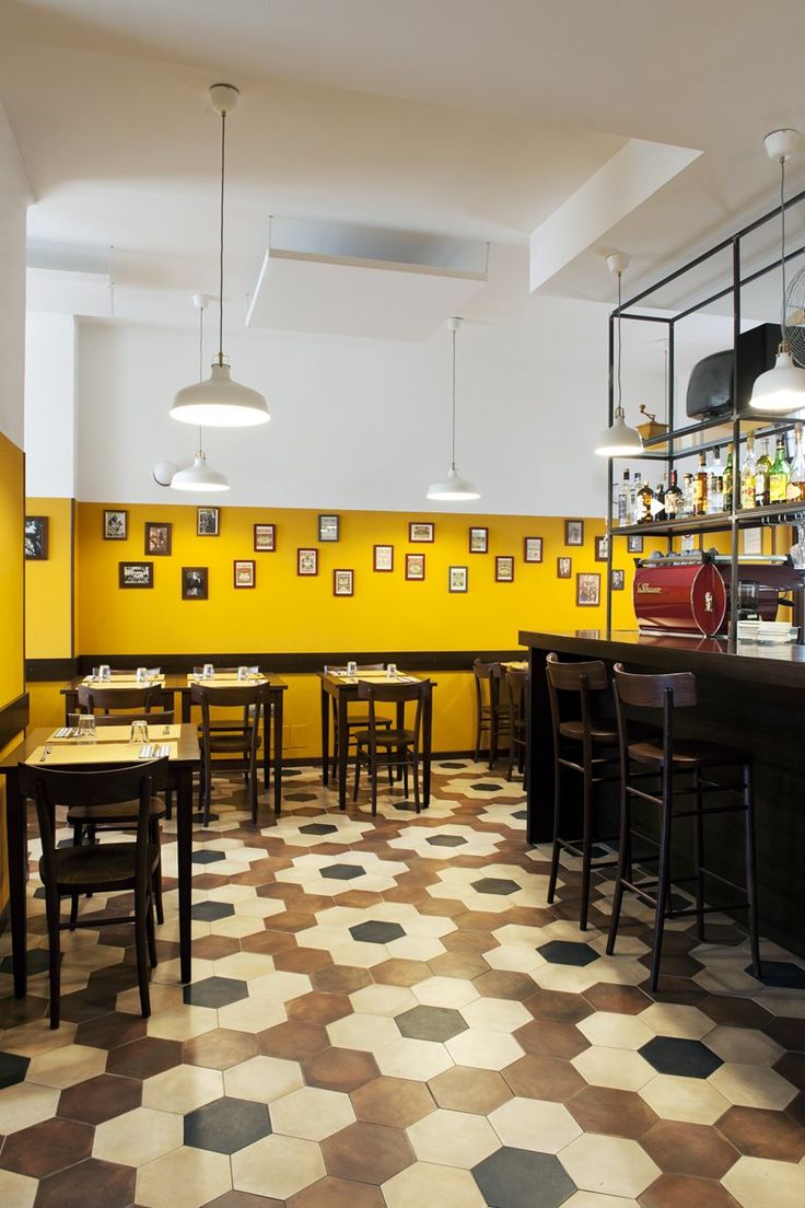 an empty restaurant with yellow walls and checkered floor