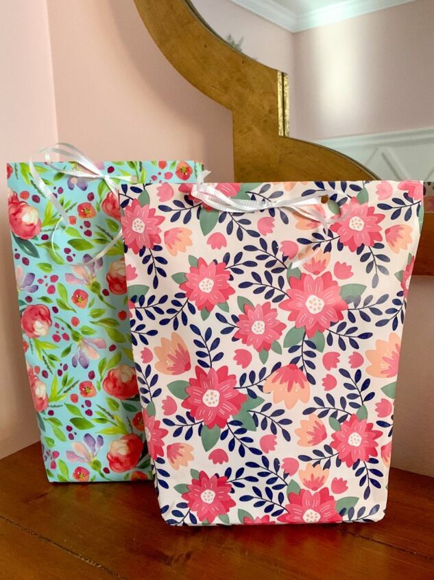 two colorful bags sitting on top of a wooden table next to a mirror and clock