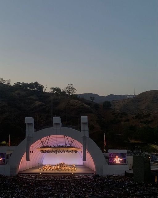 an outdoor concert venue with mountains in the background