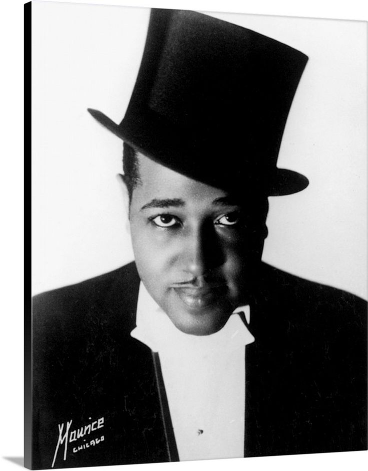 a black and white photo of a man wearing a top hat