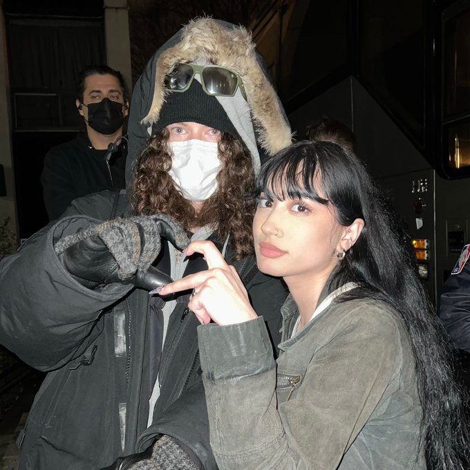 a man and woman wearing masks while standing next to each other