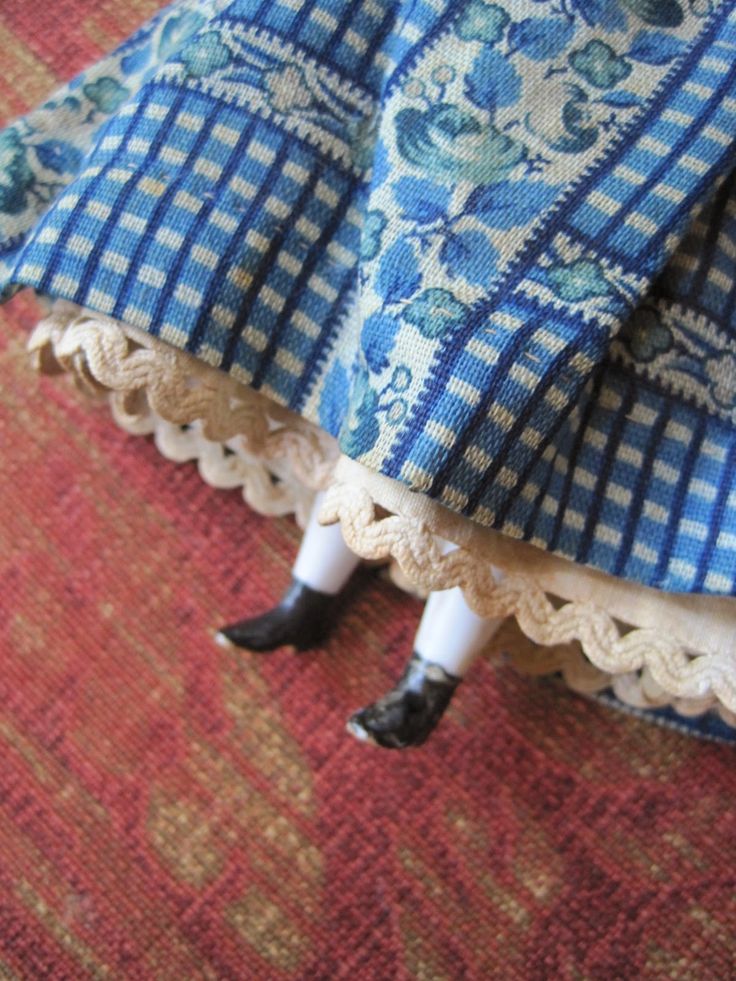 there is a doll that is laying on the floor under a blanket and covering itself