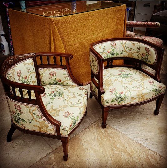 two chairs sitting next to each other in front of a wall