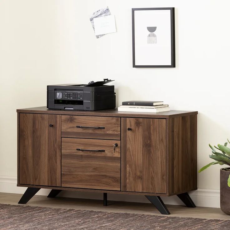 a wooden cabinet with two drawers and a printer on top, in front of a white wall