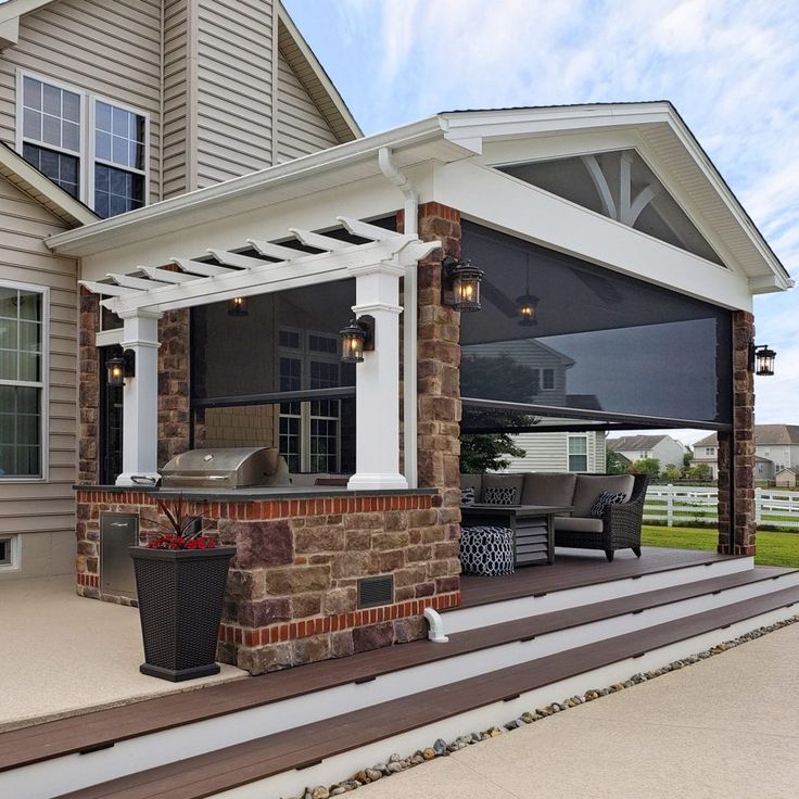 a covered patio with seating and grill area