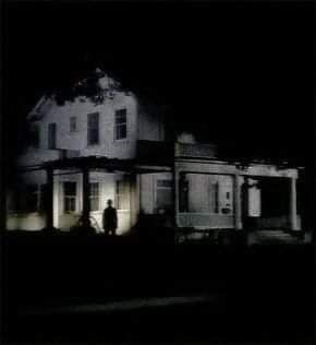 a person standing in front of a house at night