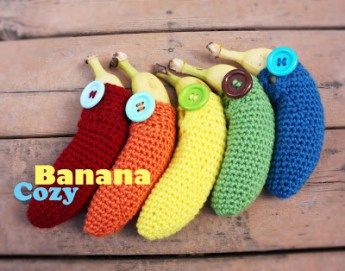 four crocheted bananas hanging on a wooden wall with buttons in the shape of banana's