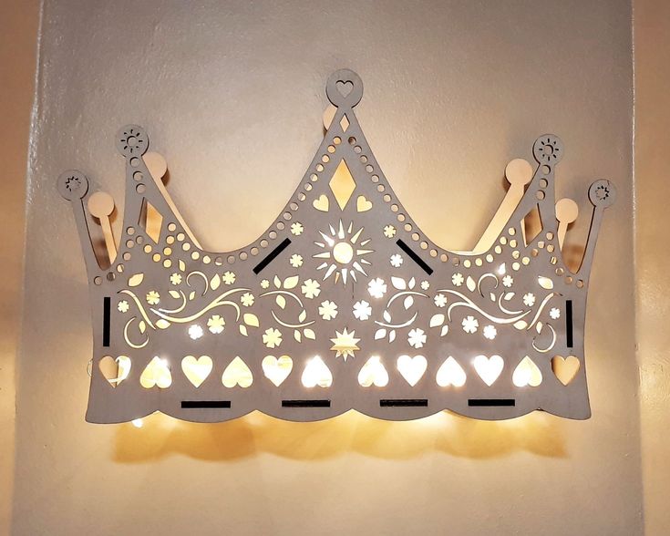 a decorative light fixture with a crown on it's side and hearts in the middle