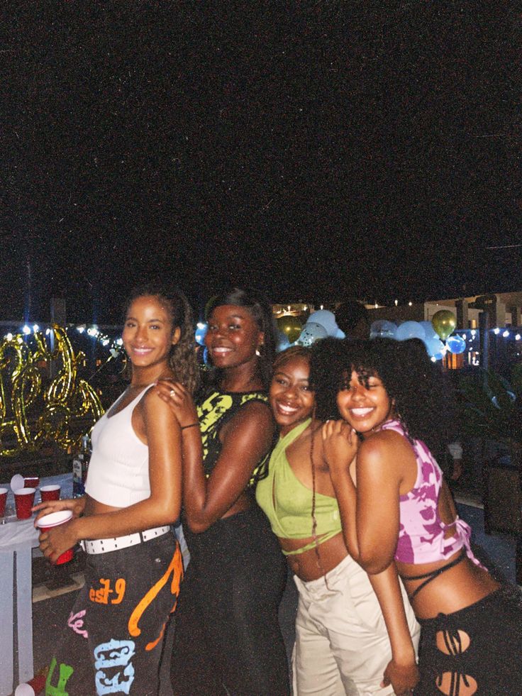 four women are posing for the camera at night