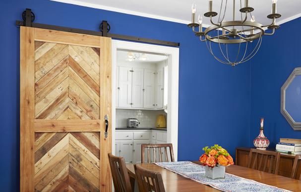 a dining room with blue walls and wooden doors