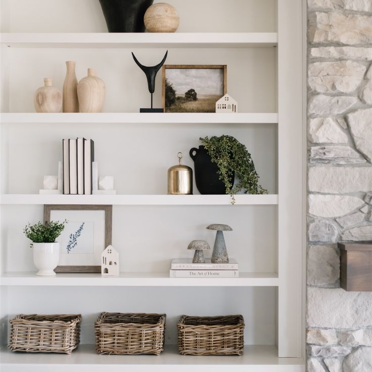 the shelves in this room are filled with vases, books and other decorative items