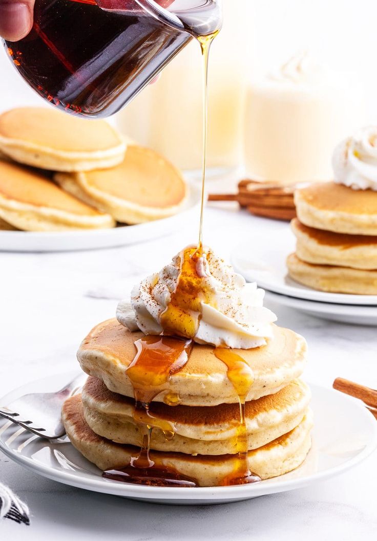 a stack of pancakes with syrup being drizzled on top