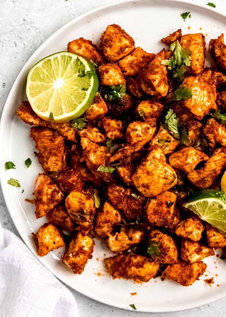 a white plate topped with chicken and limes