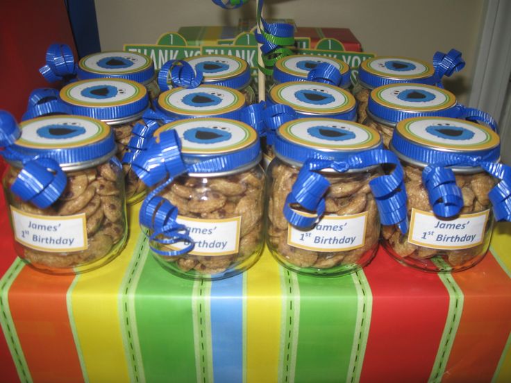 several jars filled with nuts sitting on top of a colorful table cloth covered tablecloth