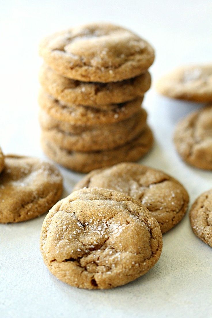 a pile of cookies sitting next to each other on a white counter top with powdered sugar all over them