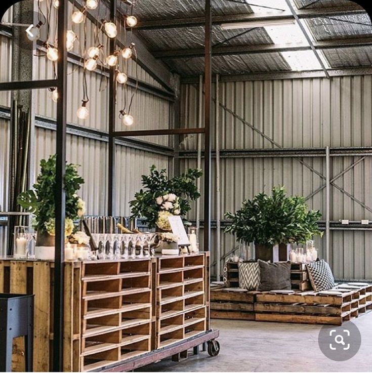 an industrial warehouse with wooden crates and plants