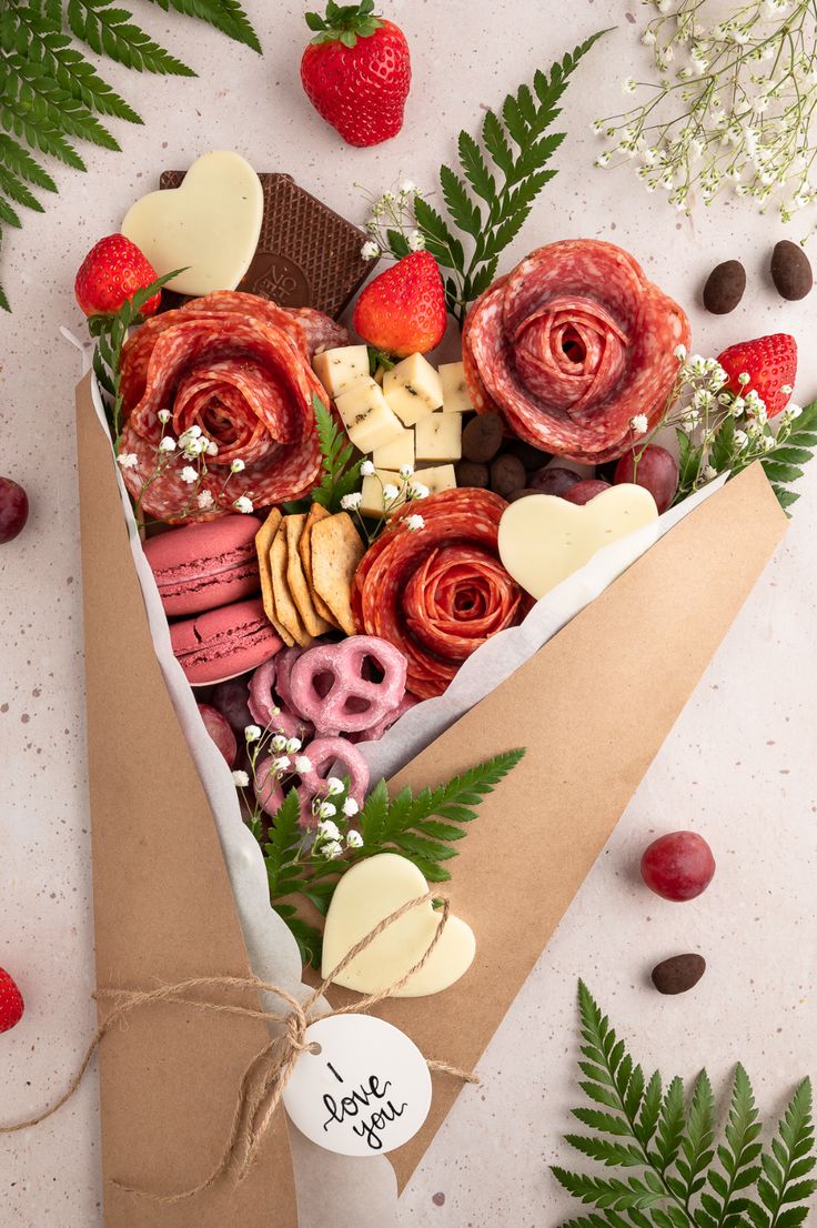 a paper bag filled with lots of different types of food next to berries and leaves