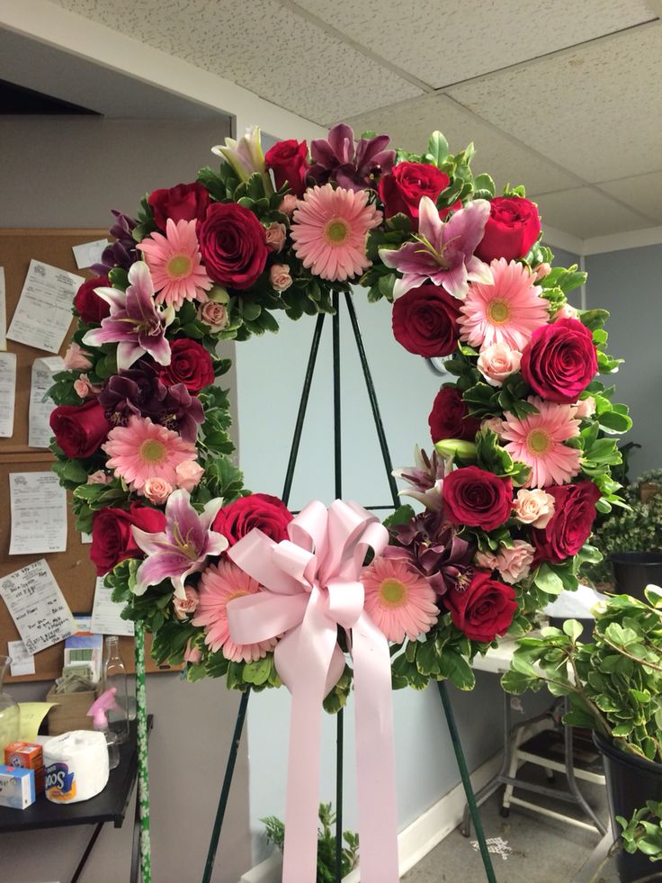 a wreath with pink and red flowers on it