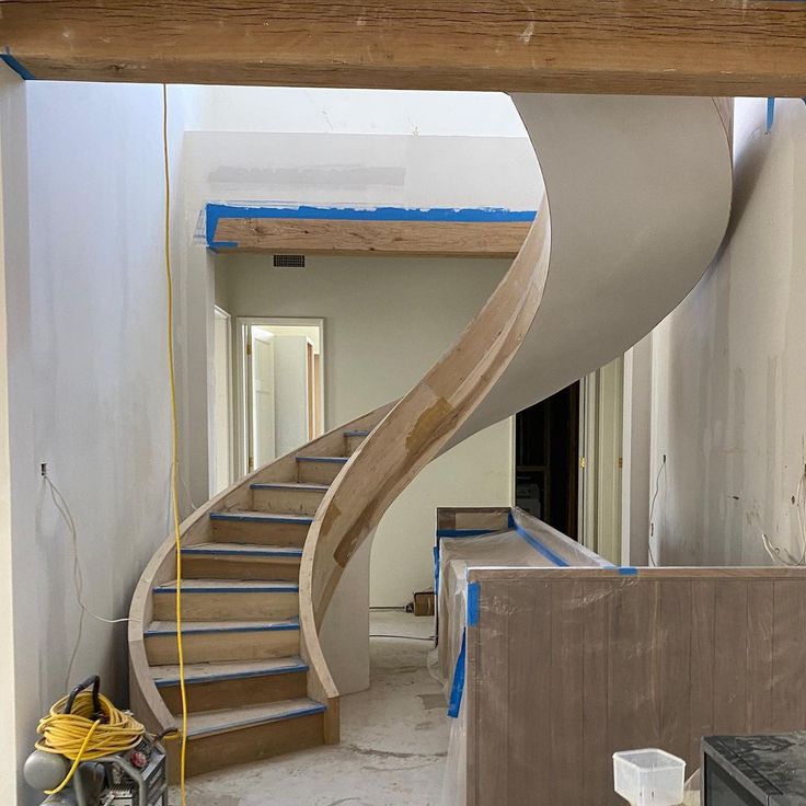 a staircase being built in a house under construction with blue tape on the floor and white walls