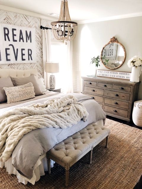 a bedroom with a bed, dressers and mirror in it's centerpiece