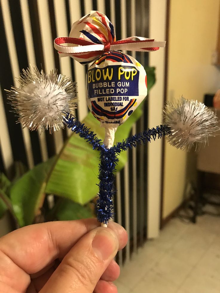 a hand holding a lollipop with some tinsel on it