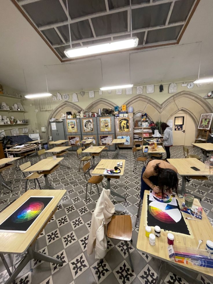 a room filled with lots of desks covered in art and painting supplies on top of them