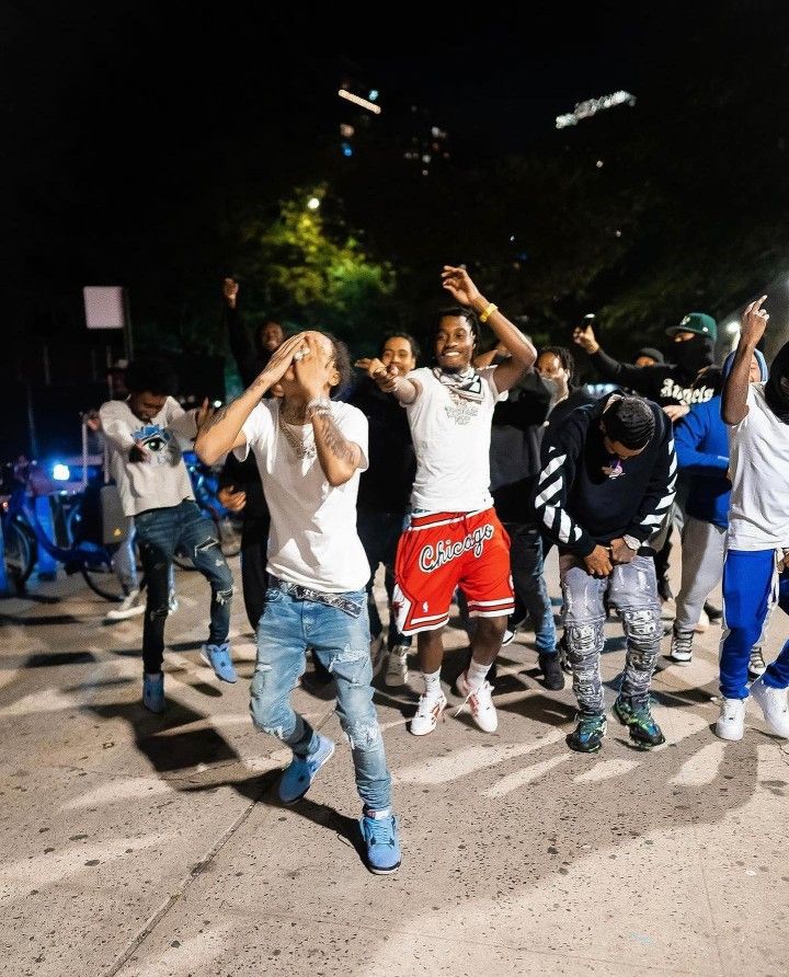 a group of young men dancing in the street at night