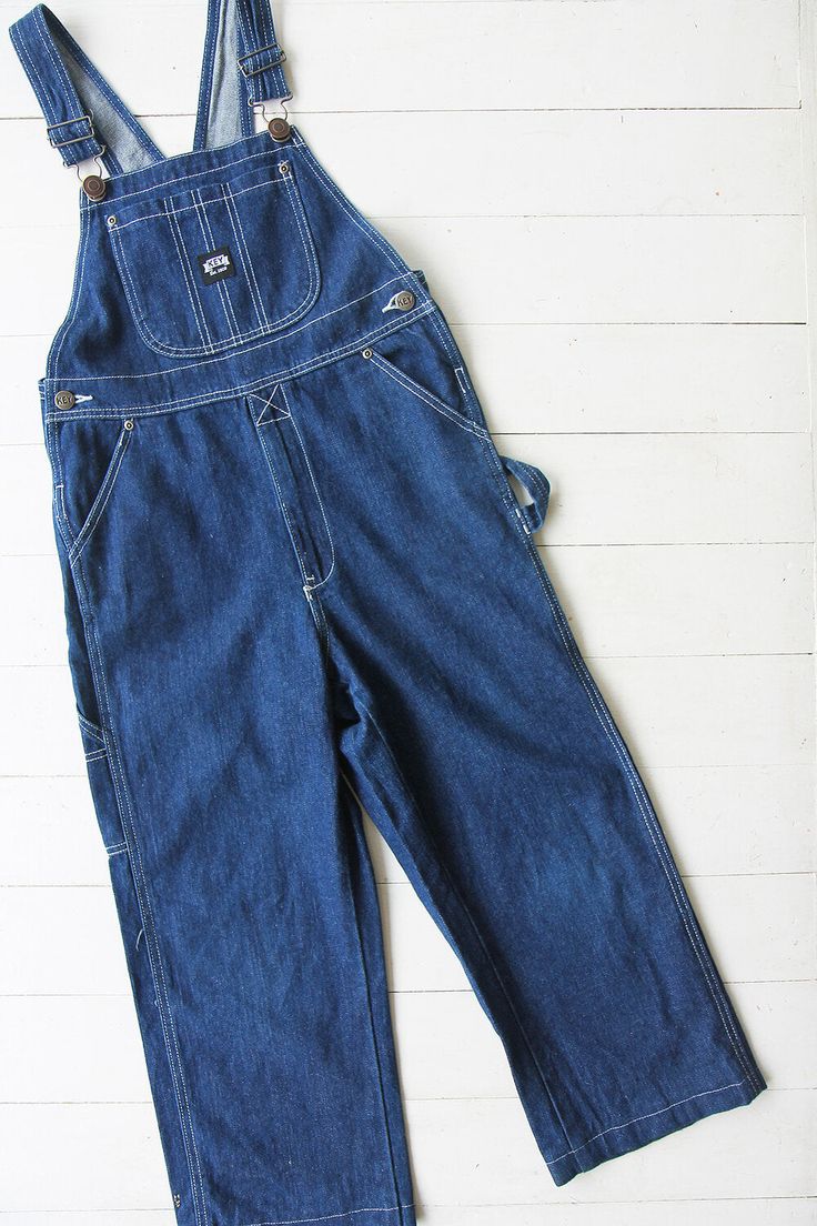 Vintage denim dungarees in blue. Single chest pocket and double waist pockets front and back. Tapered leg. UK 6 / EUR 34 Measurements - 30"(76cm) waist - 32"(81cm) hips - 21"(53cm) inner leg. Material - Denim. Condition - Excellent. Handpicked, repaired and ready to wear. This is an original vintage item, not new and minor signs of wear & age are expected, we will highlight any major flaws. Model is a UK 8 and is 5'6" tall. Utility Denim Bib Front Bottoms, Denim Bib Front Jumpsuit With Pockets, Utility Denim Bottoms With Bib Front, Denim Jumpsuit With Bib Front And Pockets, Vintage Denim Jeans With Side Pockets, Dark Wash Cotton Shortalls With Pockets, Utility Dark Wash Shortalls With Pockets, Utility Style Dark Wash Shortalls With Pockets, Denim Overalls With Patch Pockets