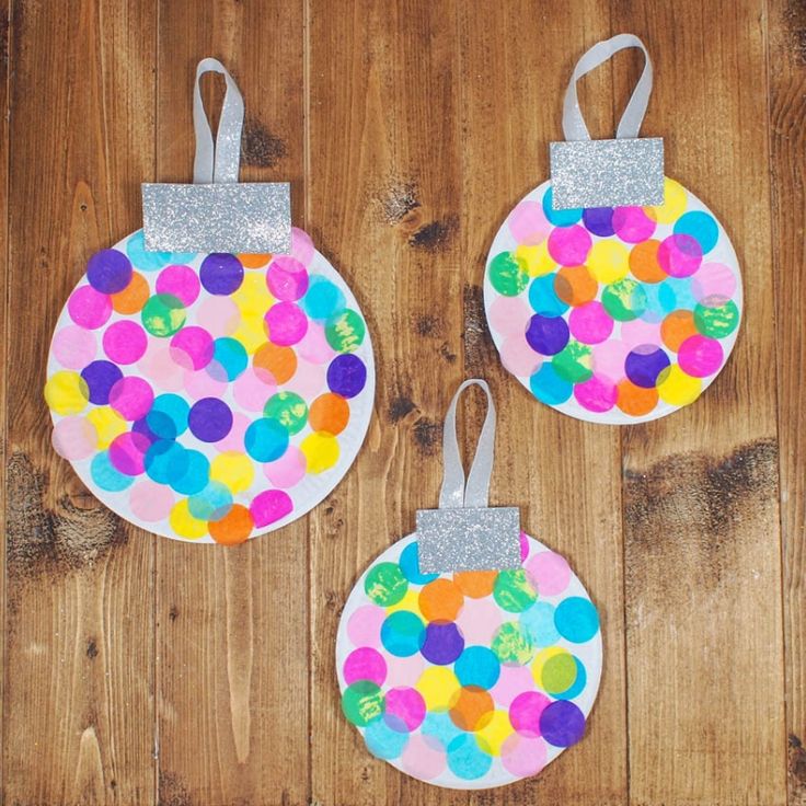 two paper plates with different colored dots on them, one is hanging from the wall