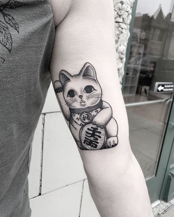 a black and white photo of a cat with chinese writing on it's arm