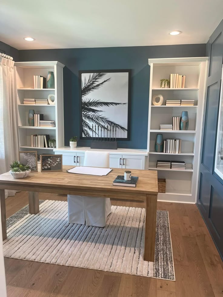 a room with bookshelves and a desk in the middle is painted teal