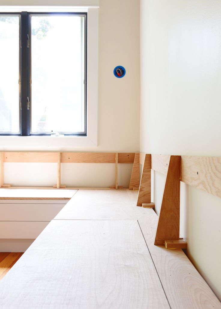 an empty bed room with no sheets on the bedspread and window in the background