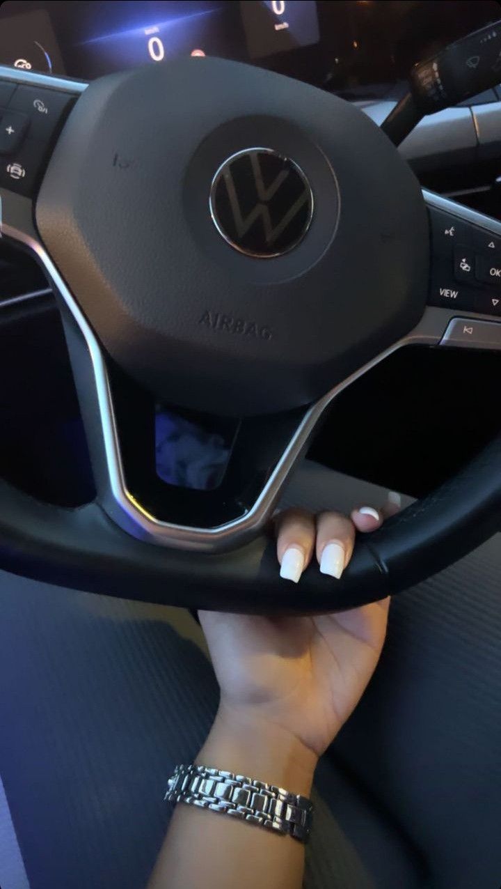 a woman is holding the steering wheel of a car with her hand on the steering wheel