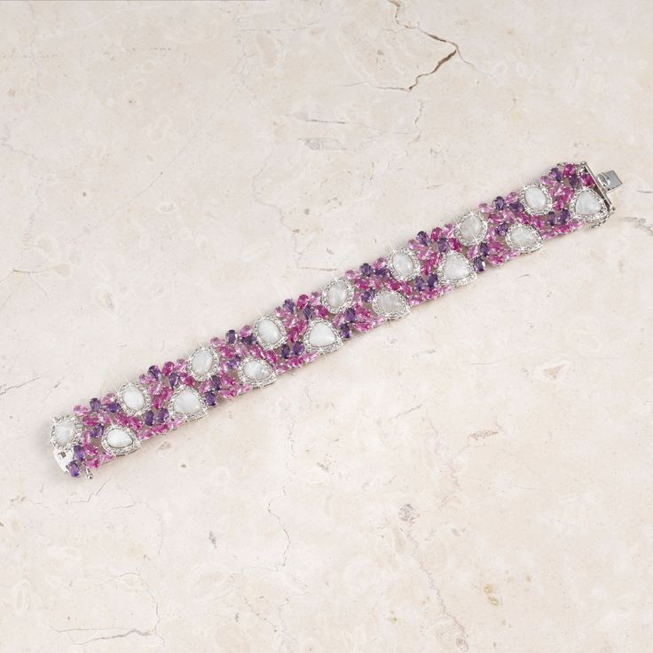 A magical display of color...This stunning bracelet is adorned with 36 amethysts, 324 white topaz, 82 created pink sapphires, and 16 moonstones. With over 450 meticulously placed stones totaling more than 43 carats in all, this bracelet is truly a masterpiece!The bracelet is plated in a combination of platinum and rhodium, ensuring a brilliant and enduring finish that perfectly complements the abundance of stones.The Cherry Blossom Bracelet is more than just jewelry; it's a captivating statement White Crystal Bracelets Fine Jewelry, Luxury Purple Tennis Bracelet, Dazzling White Bracelets With Sparkling Stones, Fine Jewelry White Bracelets With Sparkling Stones, White Bracelets With Sparkling Stones In Fine Jewelry Style, White Bracelets With Sparkling Stones Fine Jewelry, Luxury White Crystal Jubilee Bracelet, Elegant Pink Multi-stone Bracelets, White Crystal Bracelet With Sparkling Diamond Stones