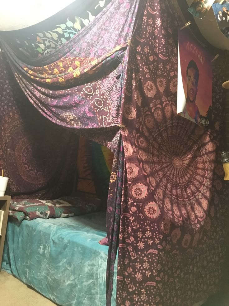 a canopy bed covered in purple and blue fabric