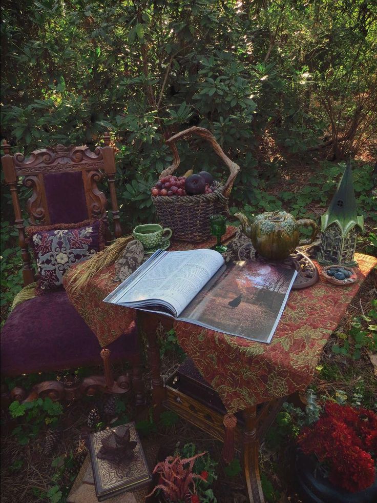 an open book sitting on top of a table surrounded by plants