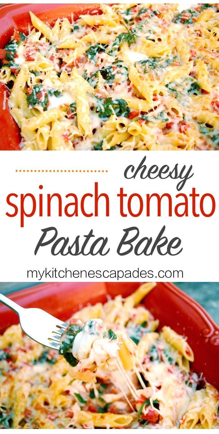 spinach and tomato pasta bake in a red casserole dish with a fork