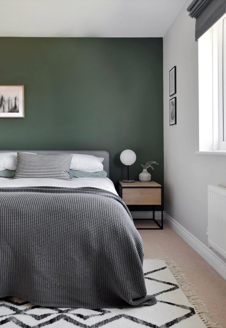 a bed sitting in a bedroom next to a wall with pictures on the side of it